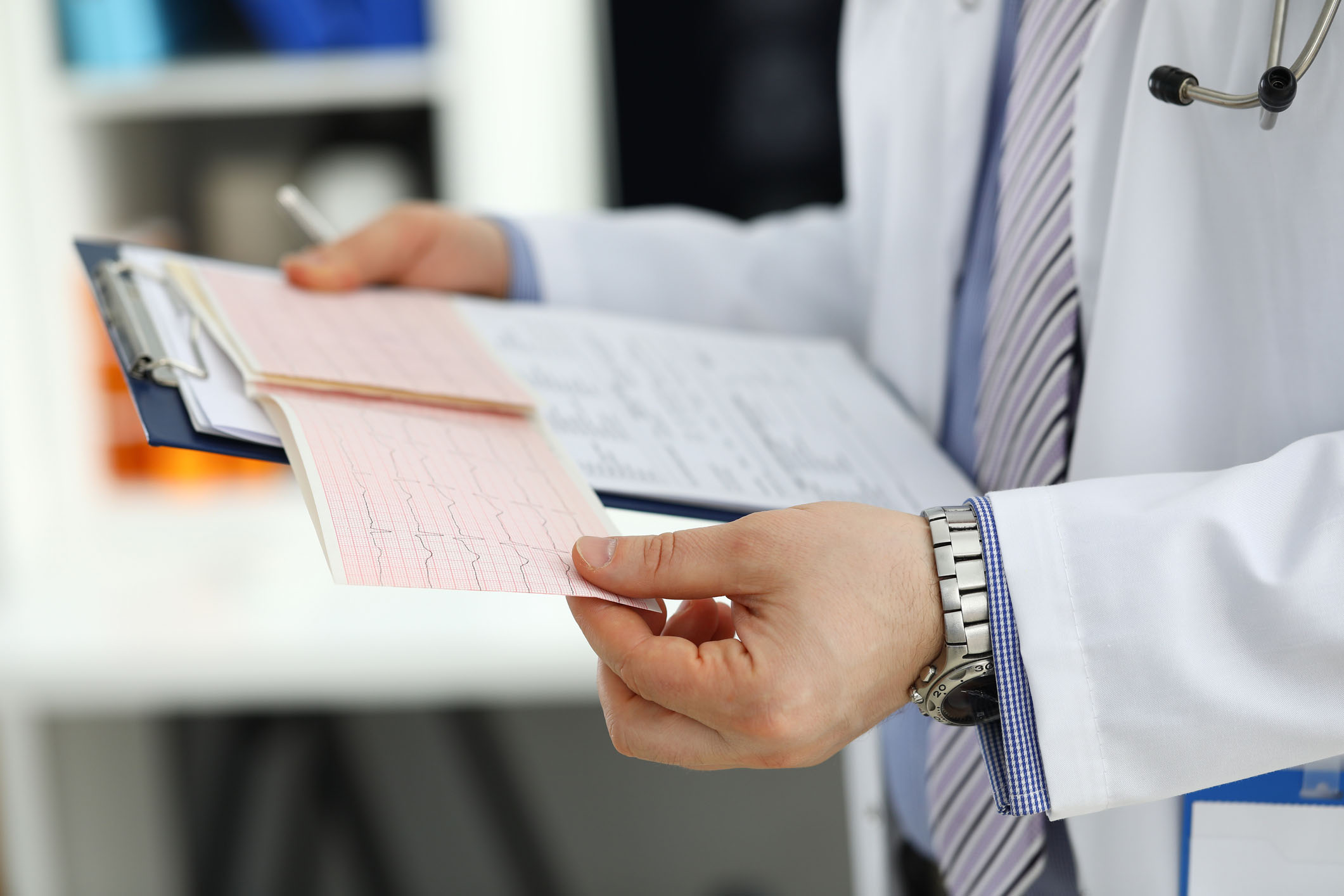 Male medicine doctor hands holding cardiogram chart