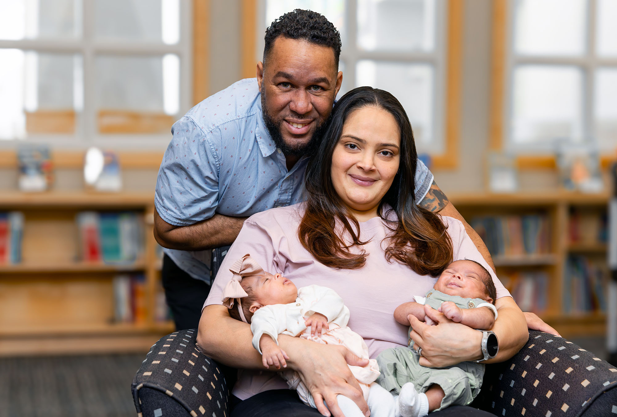 A proud young couple, mother and father, hold their twin newborn babies who were patients at Maria Fareri Children's Hospital