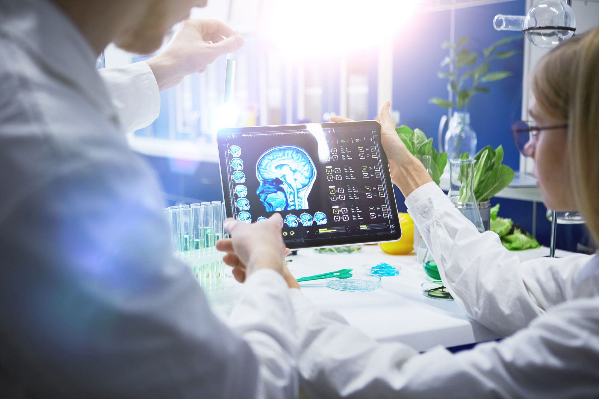 Two neuroscientists consult on a brain image of a patient in a medical office