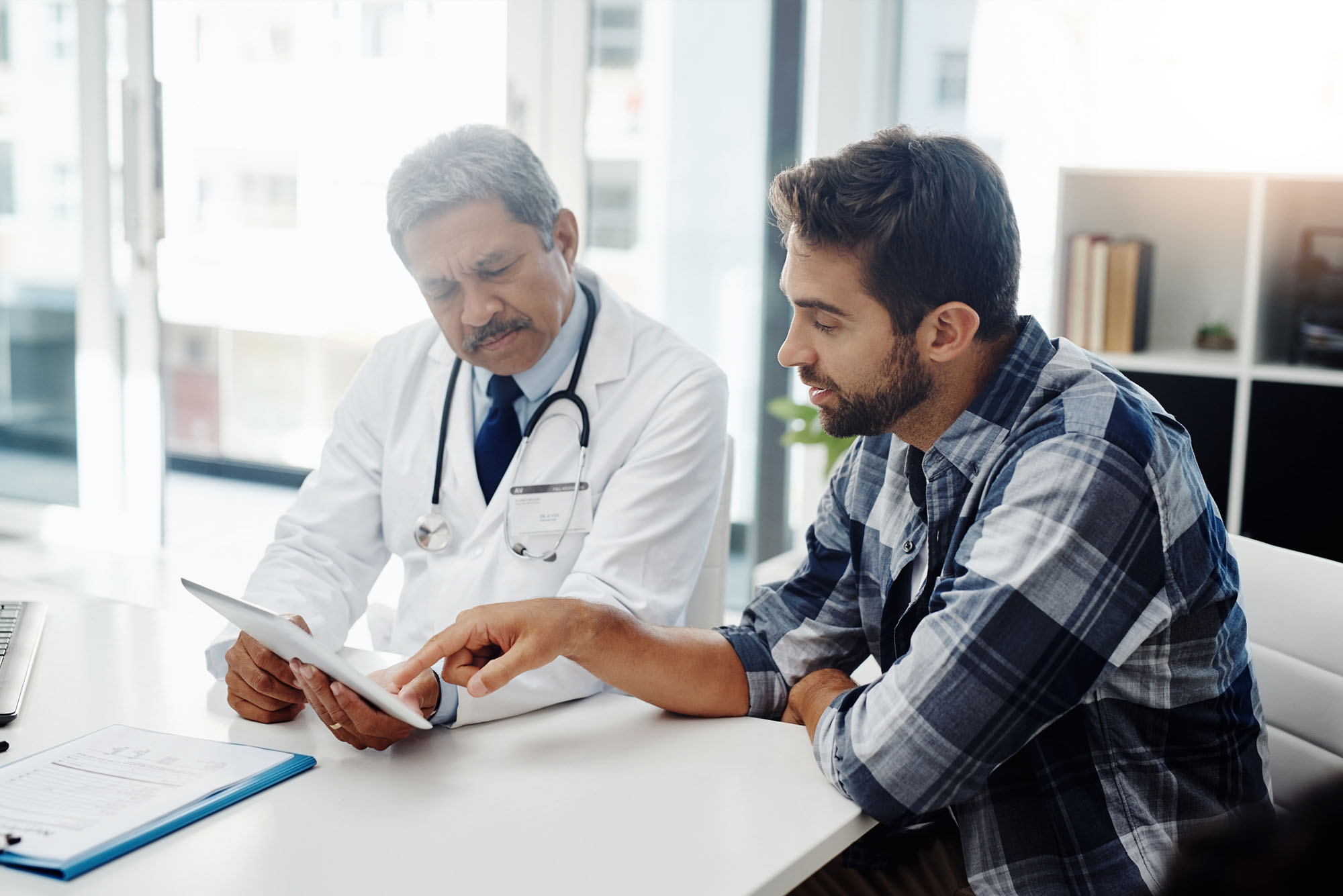 Cropped shot of a mature male doctor and patient having a discussion in the doctor's office.