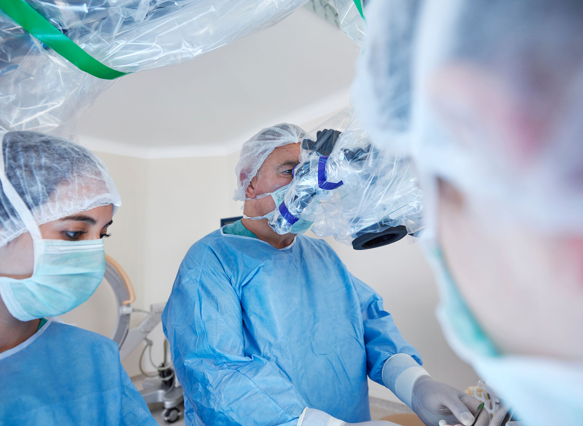 Portrait of a surgeon in an operating room performing robotic surgery.