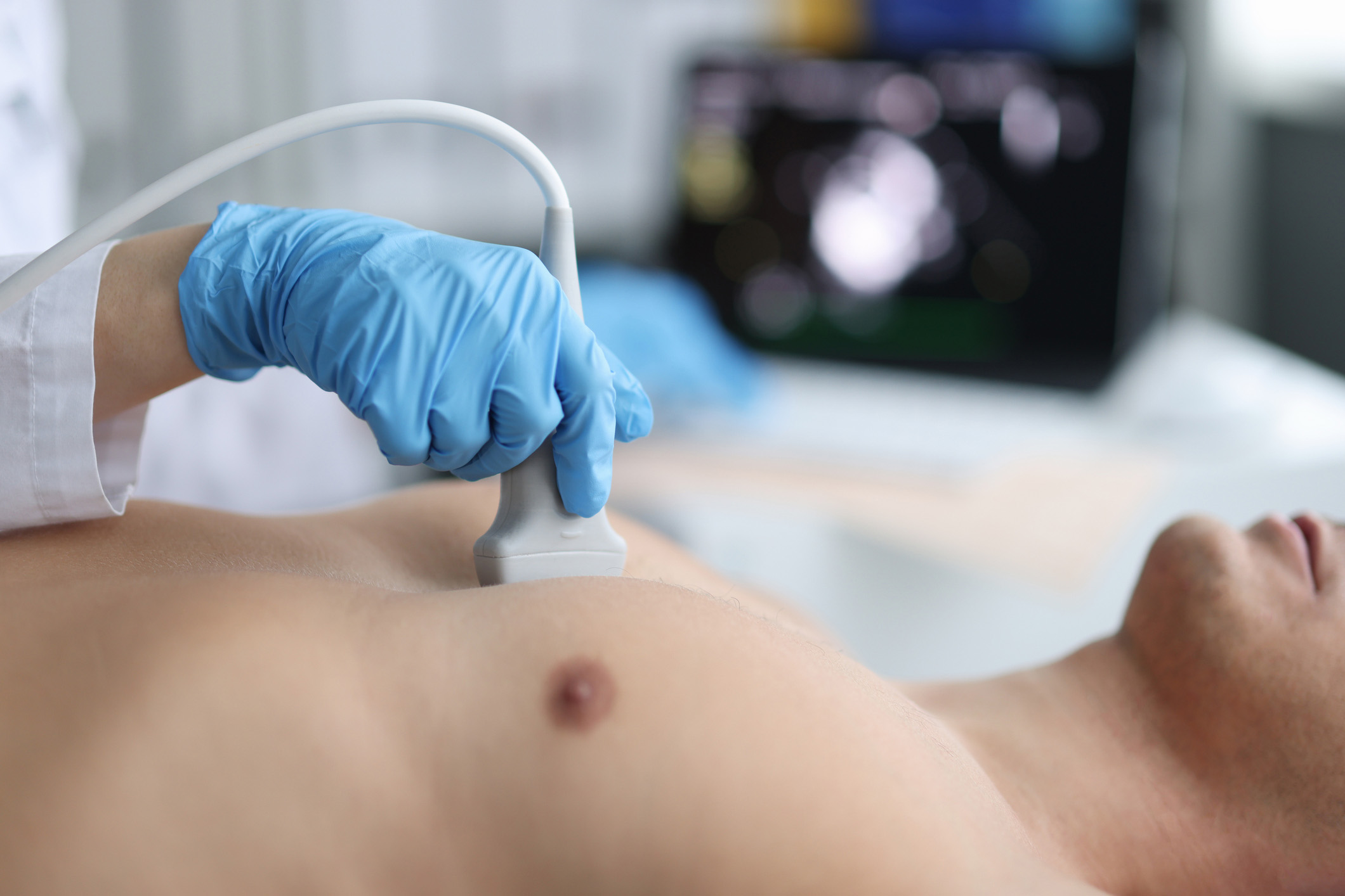 A healthcare provider performs a chest ultrasound on a male patient