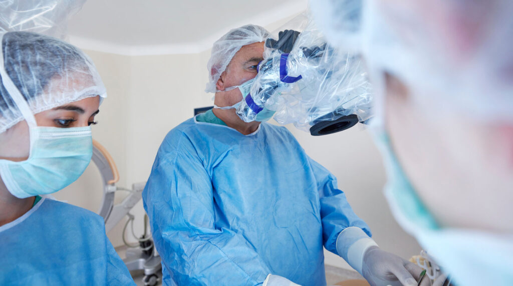 Portrait of a surgeon in an operating room performing robotic surgery.