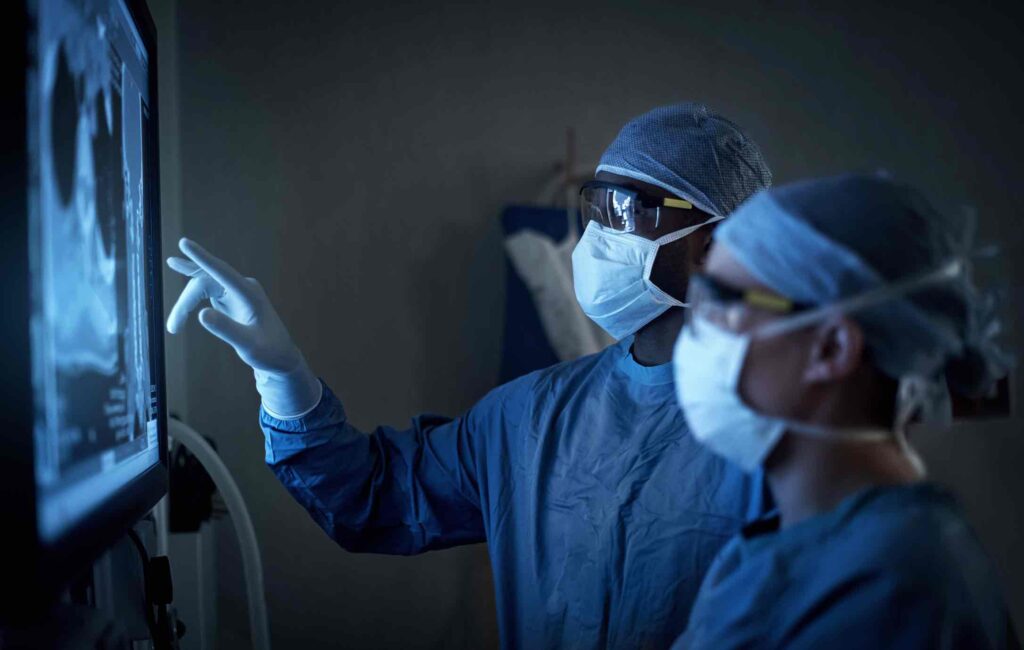 Shot of two surgeons analyzing a patient’s medical scans during surgery